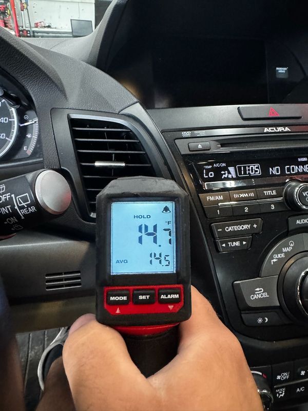Checking A/C vent temperature with a digital thermometer at Elite Diesel & Auto Works