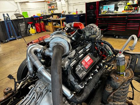 Turbocharged diesel V8 in a truck chassis with the cab removed, tool chests in the background