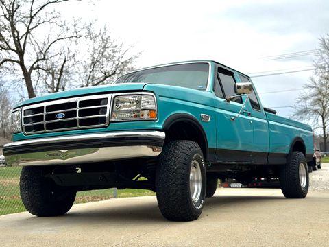Turquoise 1990s Ford F-series extended-cab pickup on all-terrain tires