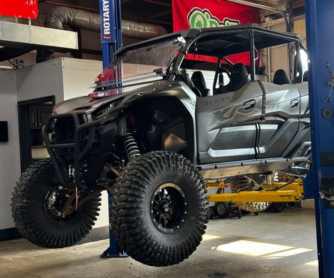 Kawasaki Teryx KRX4 side-by-side raised on a lift in the shop