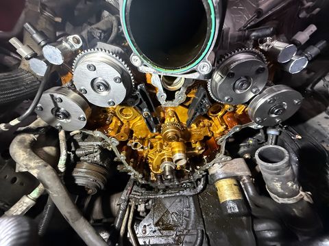 Front of an engine with the timing cover off, showing the timing chains and four cam phasers