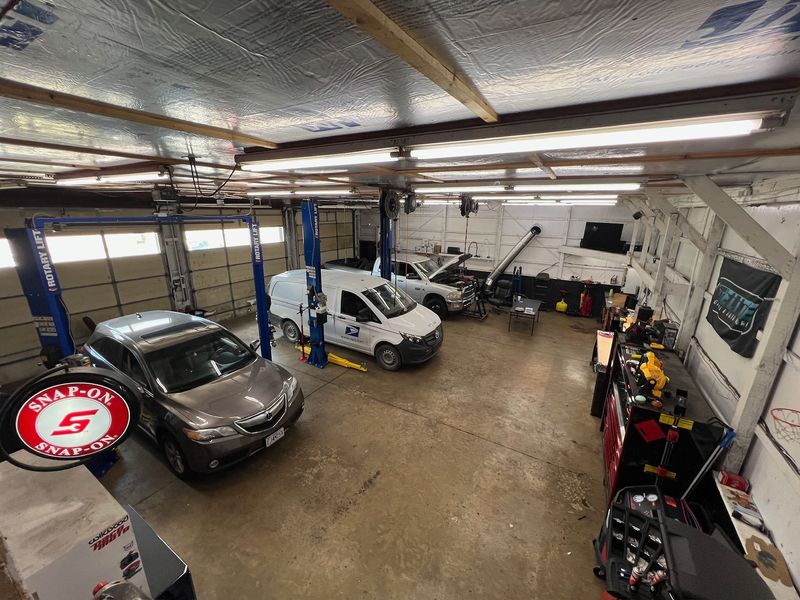 Cars and SUVs on lifts in the service bays at Elite Diesel & Auto Works