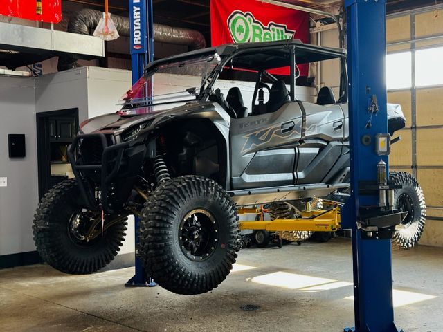 Side-by-side UTV raised on a lift inside Elite Diesel & Auto Works