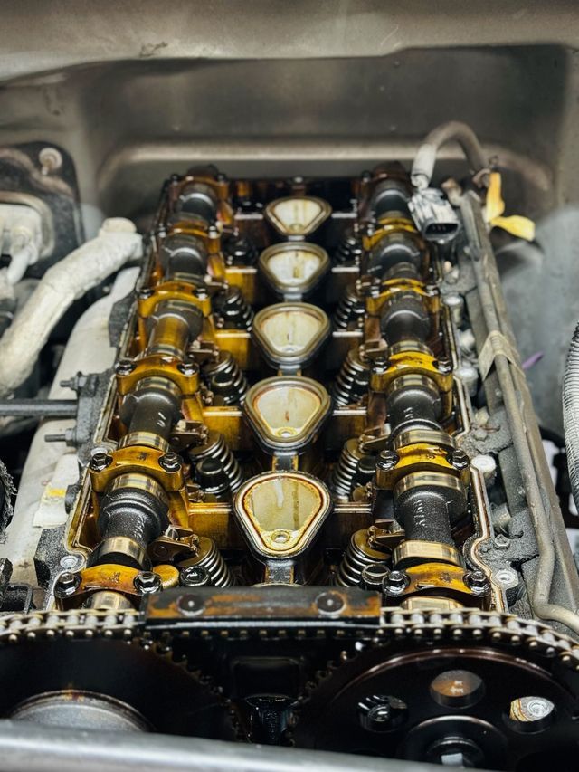 Engine with valve cover removed showing camshafts and timing components during a timing job